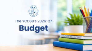 Colourful books and pencils on a desk with the YCDSB logo and the words "The YCDSB's 2026-27 Budget" appearing to the side